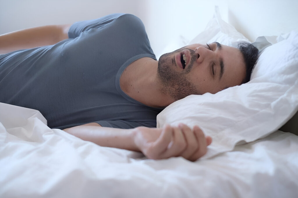 Hombre durmiendo plácidamente gracias a trucos para evitar el ronquido y mejorar el descanso