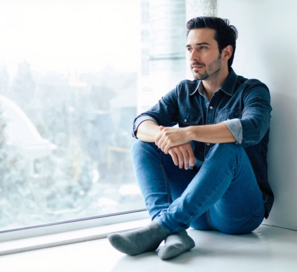 Hombre de 40 años reflexionando frente al espejo con mirada pensativa